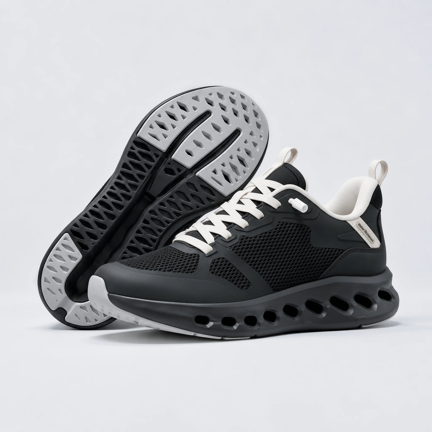 A pair of black athletic sneakers with white laces and white accents, shown from the side and sole view against a light gray background.