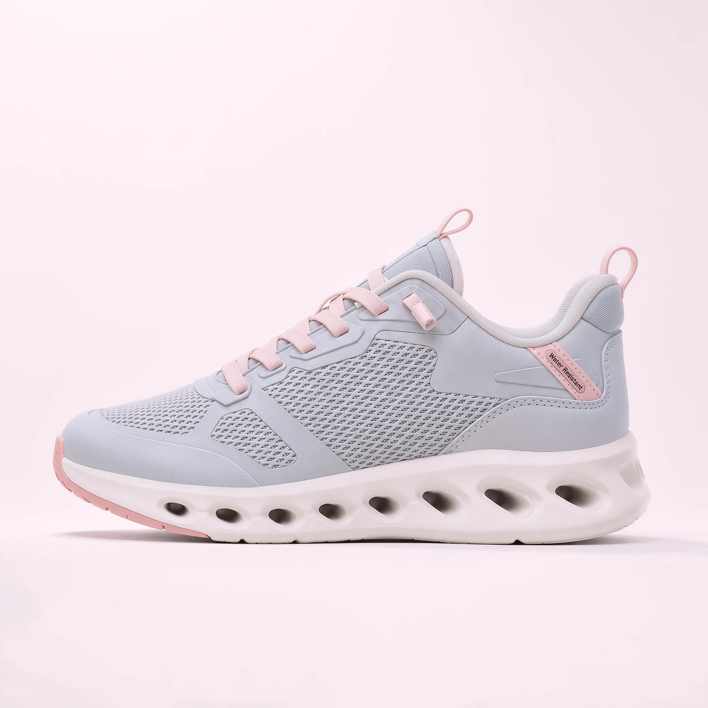 A light gray and pink athletic sneaker with a chunky white and pink sole, shown in a side profile on a pale pink background.